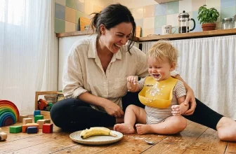 Une mère souriante joue avec son jeune enfant dans une cuisine
