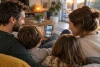 Famille consultant des nouvelles de voyage sur un smartphone à l’écran illisible